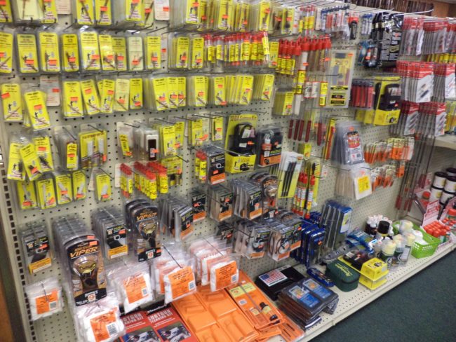 Wall display of gun cleaning supplies, firearm parts, brushes, and maintenance tools at Pickett Weaponry in Newberry, FL.
