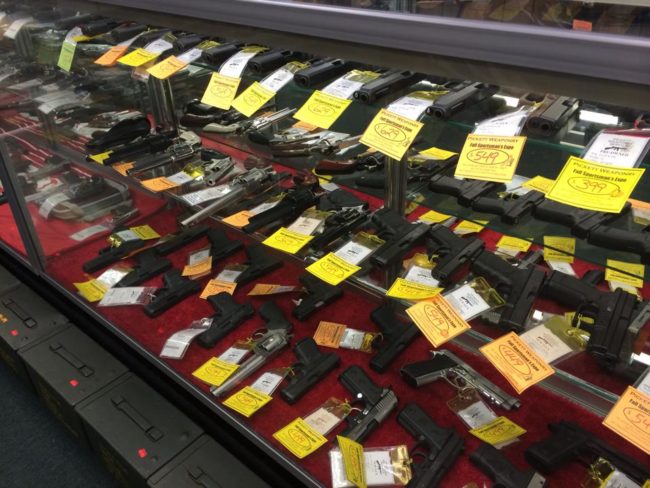Display case of handguns and antique firearms at Pickett Weaponry in Newberry, FL, showcasing a wide selection of pistols, revolvers.