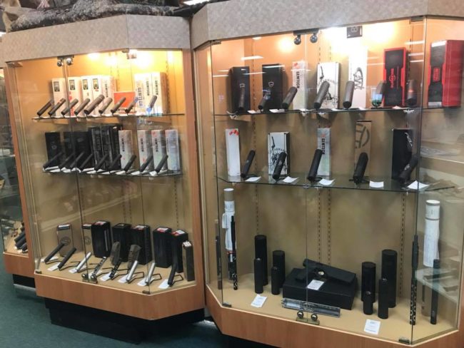Multiple display cases of firearm suppressors and silencers at Pickett Weaponry, featuring Gemtech, Dead Air, and other Class III NFA brands in stock.